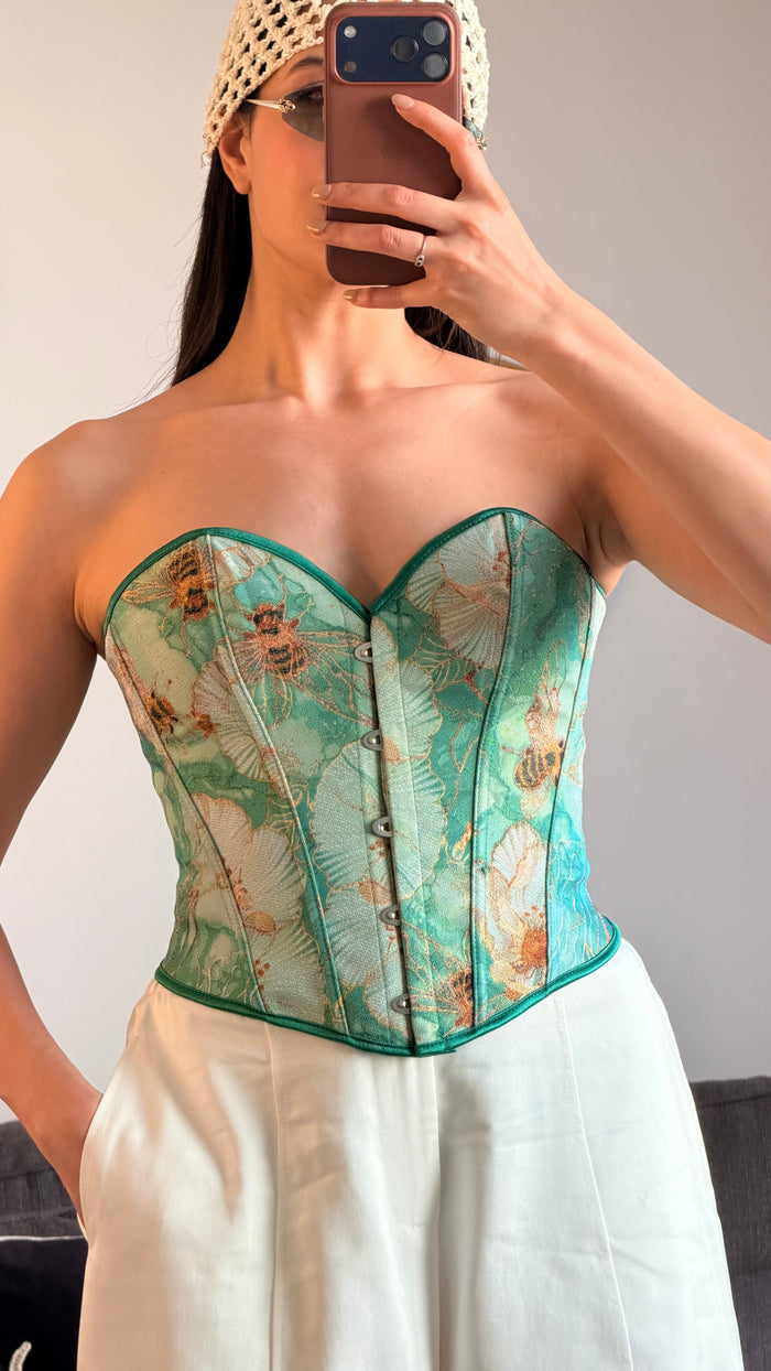 Corset bustier vert imprimé floral porté avec jupe blanche — ORÉ Paris